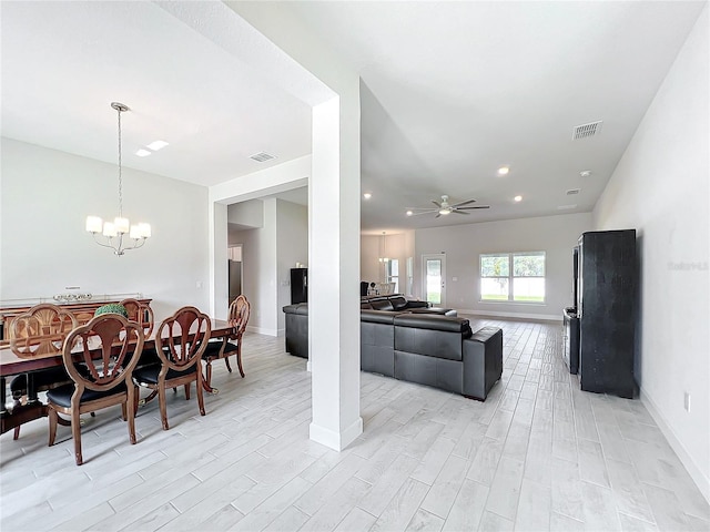 living room featuring ceiling fan with notable chandelier and light wood-type flooring