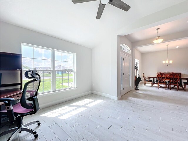 office space with light hardwood / wood-style flooring and ceiling fan with notable chandelier