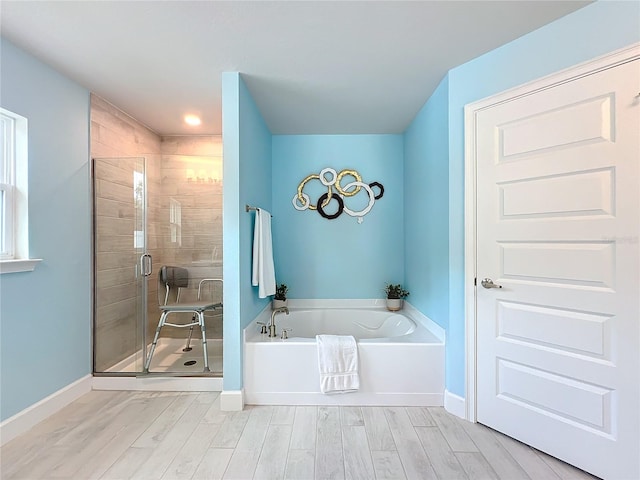 bathroom featuring hardwood / wood-style flooring and plus walk in shower