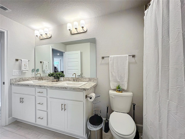 bathroom featuring vanity, toilet, and a textured ceiling