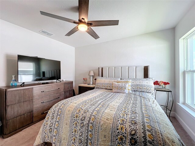 bedroom with ceiling fan and light colored carpet