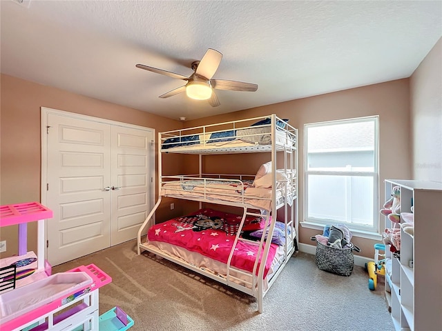 bedroom with a closet, ceiling fan, a textured ceiling, and carpet floors