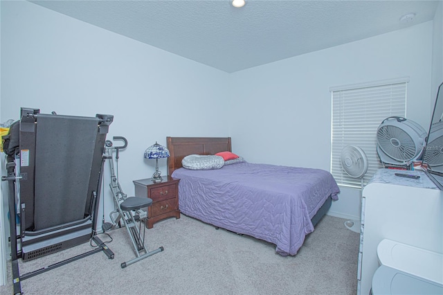 bedroom featuring a textured ceiling and light colored carpet