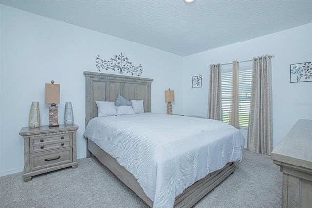 bedroom featuring light carpet and a textured ceiling