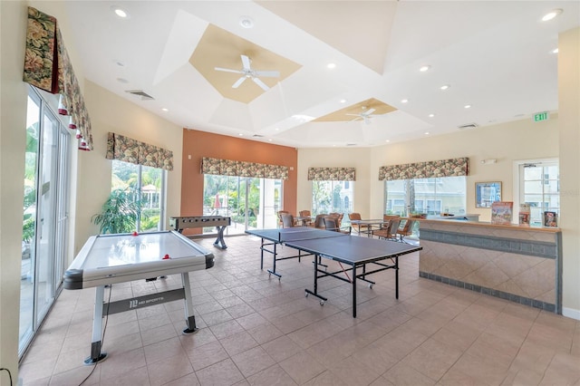 rec room with billiards, a towering ceiling, a tray ceiling, light tile patterned flooring, and ceiling fan