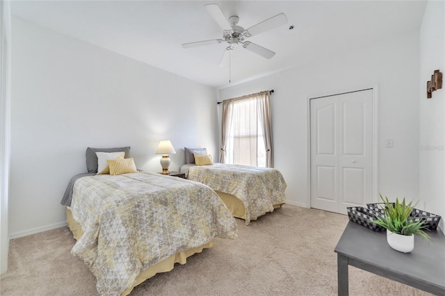 carpeted bedroom with ceiling fan and a closet