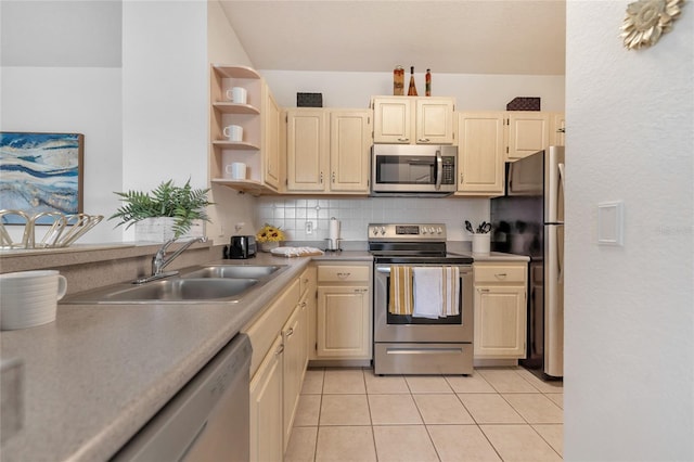 kitchen featuring appliances with stainless steel finishes, decorative backsplash, sink, and light tile patterned floors