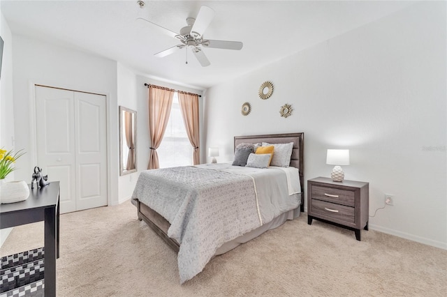 bedroom with ceiling fan, a closet, and light carpet