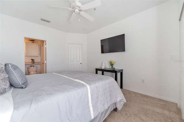 bedroom featuring ceiling fan, light colored carpet, connected bathroom, and a closet