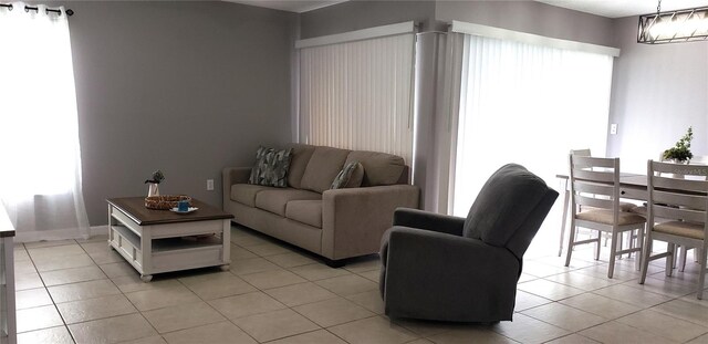 tiled living room featuring a chandelier