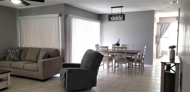 dining room with light tile patterned flooring, a textured ceiling, and ceiling fan