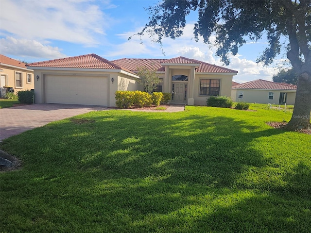 mediterranean / spanish home with a garage and a front lawn