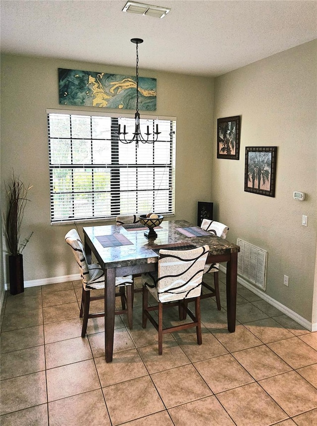 tiled dining room with a chandelier