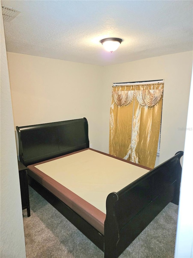 carpeted bedroom with a textured ceiling