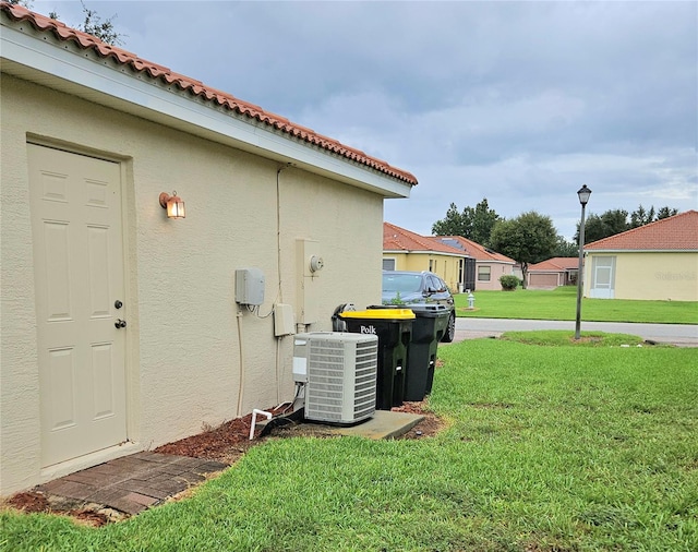 view of property exterior featuring a lawn and central AC unit