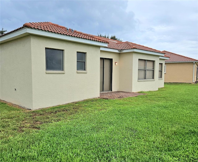 back of house with a yard and a patio