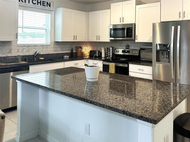 kitchen with backsplash, white cabinetry, and stainless steel appliances