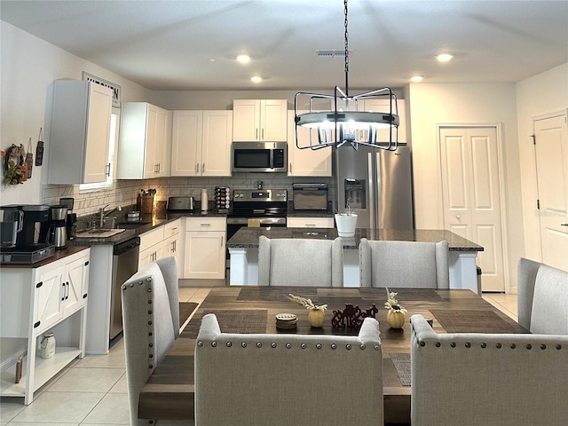 kitchen featuring pendant lighting, a center island, white cabinets, and stainless steel appliances