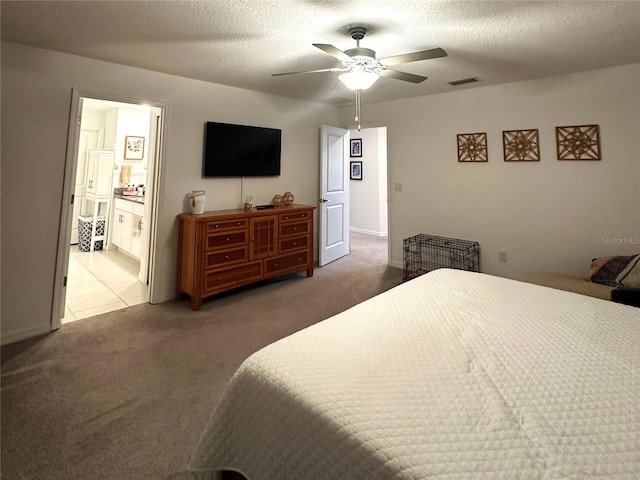 carpeted bedroom featuring a textured ceiling, connected bathroom, and ceiling fan