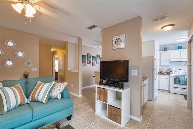 living area featuring visible vents, baseboards, ceiling fan, and light tile patterned floors