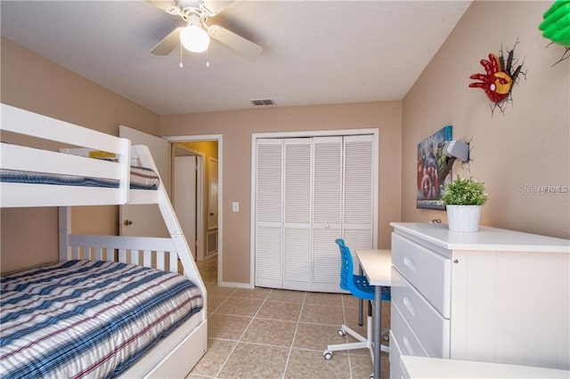 bedroom with a closet, light tile patterned floors, and ceiling fan