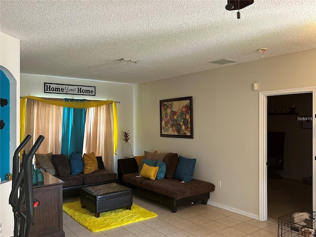 living room with a textured ceiling and light tile patterned floors