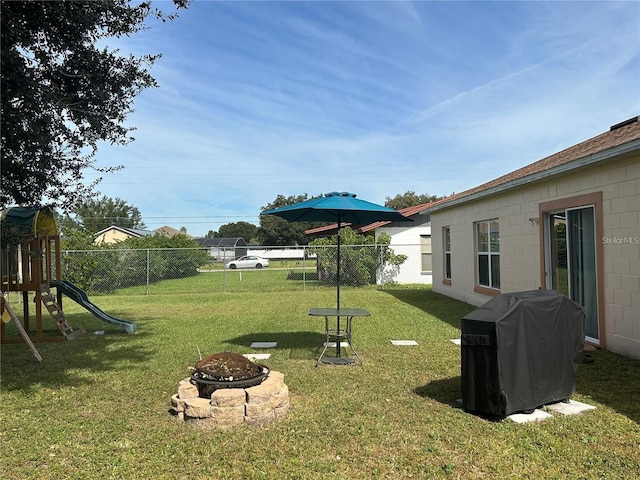 view of yard featuring an outdoor fire pit and a playground