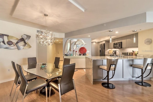 dining area featuring a chandelier and light wood-type flooring