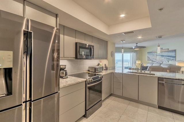 kitchen featuring appliances with stainless steel finishes, sink, decorative backsplash, and gray cabinets