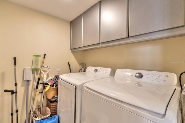 washroom featuring washer and clothes dryer and cabinets