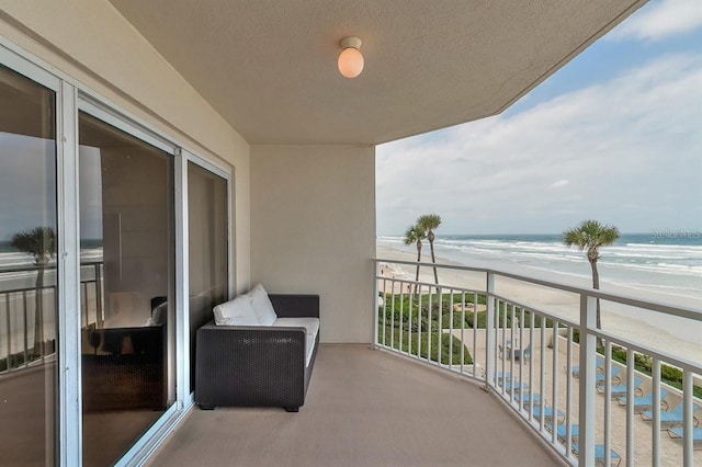 balcony featuring a water view and a beach view