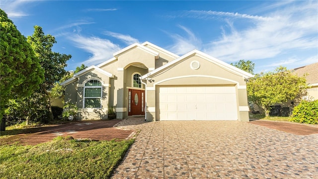 223 Lake Davenport Ests, Davenport, FL 33897 - view of front of home with stucco siding, decorative driveway, and an attached garage