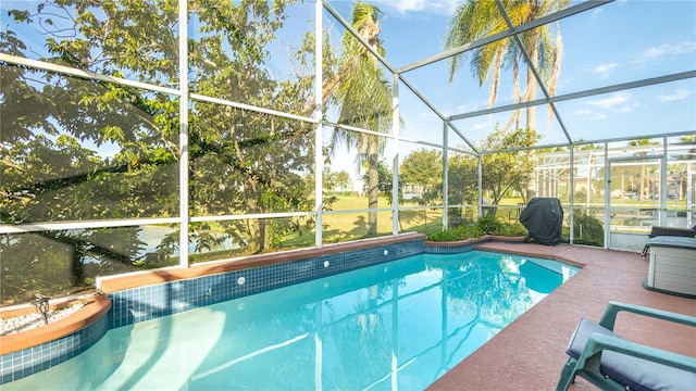 view of swimming pool with a patio, grilling area, and glass enclosure