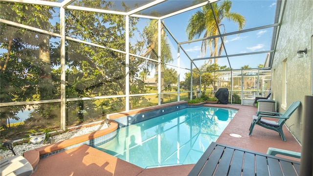 view of swimming pool featuring a patio and a lanai