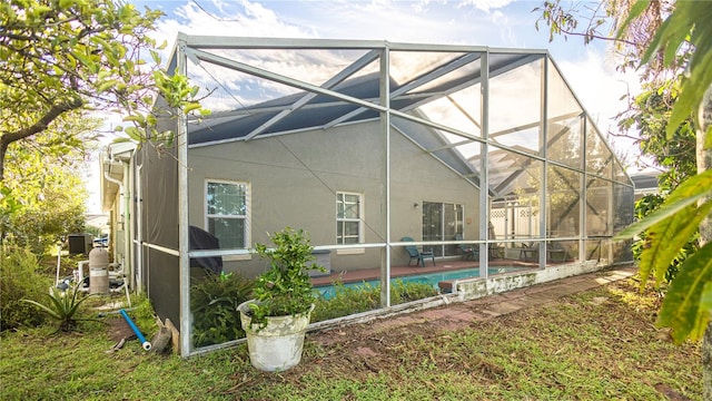 back of property featuring a patio and glass enclosure