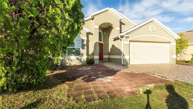 223 Lake Davenport Ests, Davenport, FL 33897 - view of front of house with decorative driveway, a garage, and stucco siding