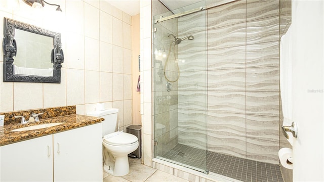 223 Lake Davenport Ests, Davenport, FL 33897 - bathroom featuring tile walls, a stall shower, toilet, tile patterned floors, and vanity