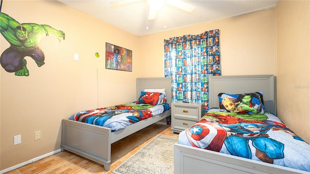 bedroom featuring light hardwood / wood-style flooring, a textured ceiling, and ceiling fan