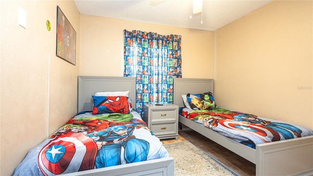 bedroom featuring a textured ceiling, wood-type flooring, and ceiling fan