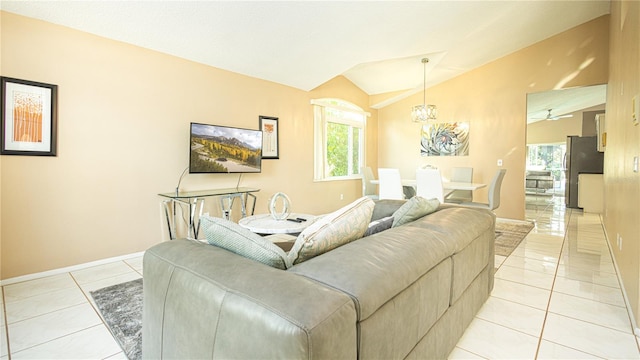 living room featuring vaulted ceiling, an inviting chandelier, and light tile patterned floors