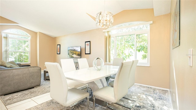 tiled dining room featuring a notable chandelier, a healthy amount of sunlight, and vaulted ceiling