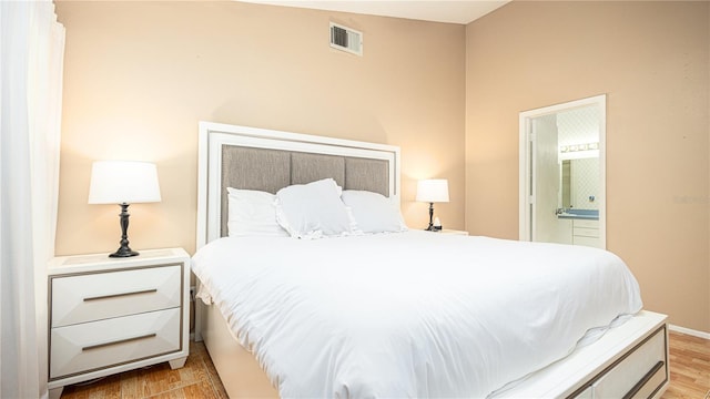 bedroom featuring light hardwood / wood-style floors and ensuite bathroom