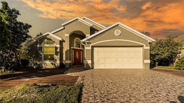 223 Lake Davenport Ests, Davenport, FL 33897 - view of front of home featuring stucco siding, decorative driveway, and an attached garage