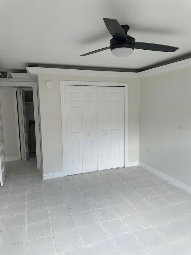 unfurnished bedroom featuring light tile patterned floors, ornamental molding, a closet, and ceiling fan