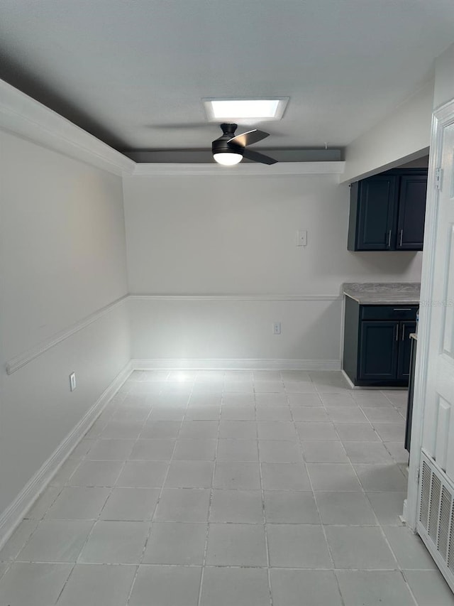 tiled empty room featuring ceiling fan