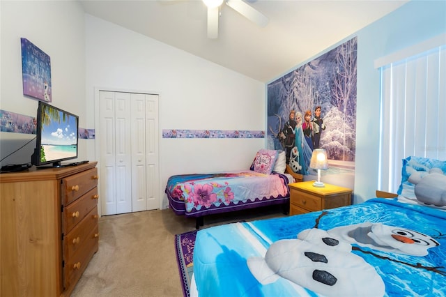 bedroom with ceiling fan, a closet, light colored carpet, and vaulted ceiling