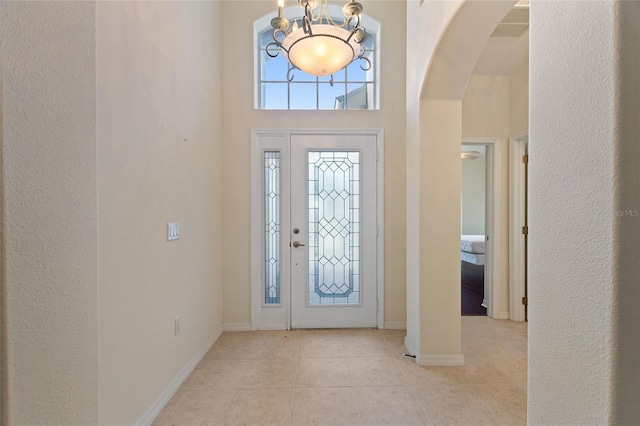 foyer with a high ceiling and light tile patterned floors