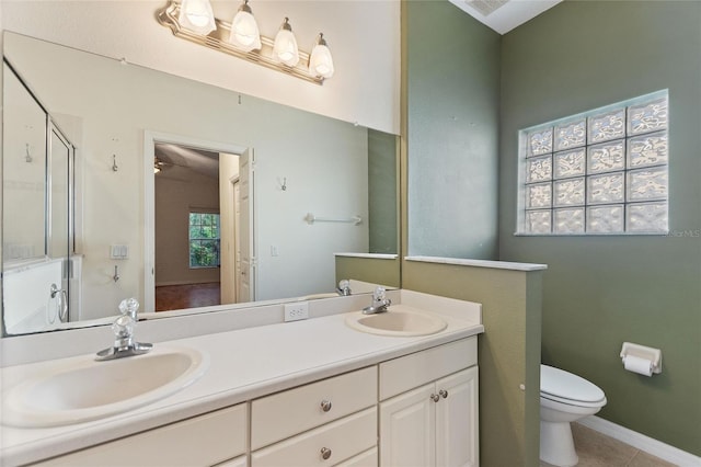 bathroom featuring vanity, toilet, a healthy amount of sunlight, and tile patterned flooring