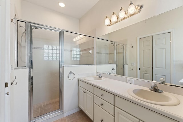 bathroom featuring vanity, a shower with shower door, and tile patterned flooring