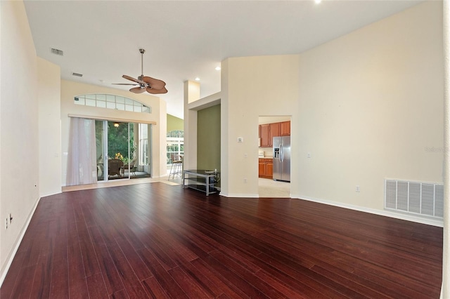 unfurnished living room with light hardwood / wood-style floors, a high ceiling, and ceiling fan